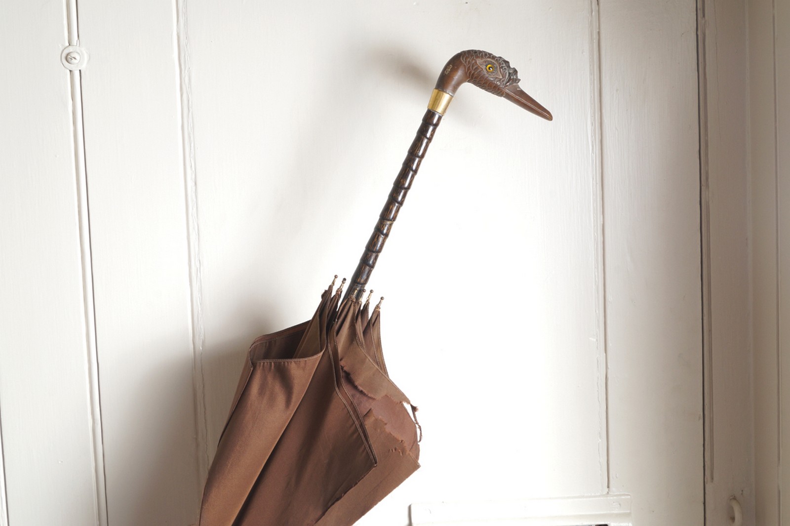 NINETEENTH-CENTURY HARDWOOD STEMMED UMBRELLA with a bird head handle and gold ferrule Direct all