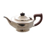 SILVER TEAPOT of oval faceted form, with a moulded scroll handle and emerald cut finial, raised on a