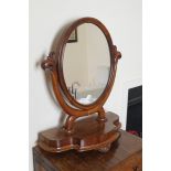 VICTORIAN MAHOGANY CRUTCH MIRROR the oval plate within a moulded frame, nestled on bateau forming