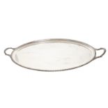 LARGE SILVER SERVING TRAY of oval form with a moulded and beaded border, furnished with leaf and