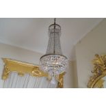 EDWARDIAN BRASS AND CRYSTAL BELL SHAPED CHANDELIER draped with emerald-cut facets and crystal prisms
