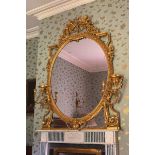 NINETEENTH-CENTURY GILT-FRAMED OVER MANTEL MIRROR the oval plate within a ribbon and egg moulded