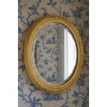 SMALL NINETEENTH-CENTURY GILT FRAMED MIRROR the oval bevelled plate within an Arabesque and an