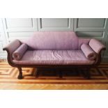 REGENCY PERIOD MAHOGANY SCROLL END LIBRARY SETTEE of bateau form, with a stepped scroll back, raised