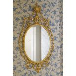 GEORGE III PERIOD GILTWOOD AND GESSO PIER MIRROR the oval plate within a gadrooned border, draped