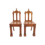 Pair of oak late nineteenth-century Gothic hall chairseach with a paneled seat raised on paneled