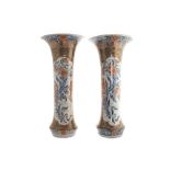 Pair of Japanese eighteenth-century Arita period trumpet necked vases each raised on a carved wood