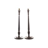 Pair of nineteenth-century mahogany candle sticks each with a reeded turn stem and circular base (