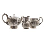 Three piece crested silver tea service each of bulbous form with leaf and scroll embossed