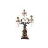 Pair of Regency bronze and crystal candelabras each raised on a wing-spread eagle, on a rams head