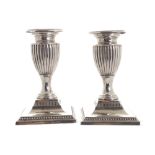 Pair of silver candlesticks each with a reeded baluster stem and square base, Sheffield, 1897-1898