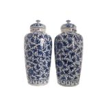 Pair of Chinese Qing period blue and white urns and covers each with all over floral and leaf