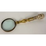 Opening: 90 EUR    UNUSUAL MAGNIFIER WITH JANUS HEAD HANDLE Brass. Handle probably bone. L.32,5cm