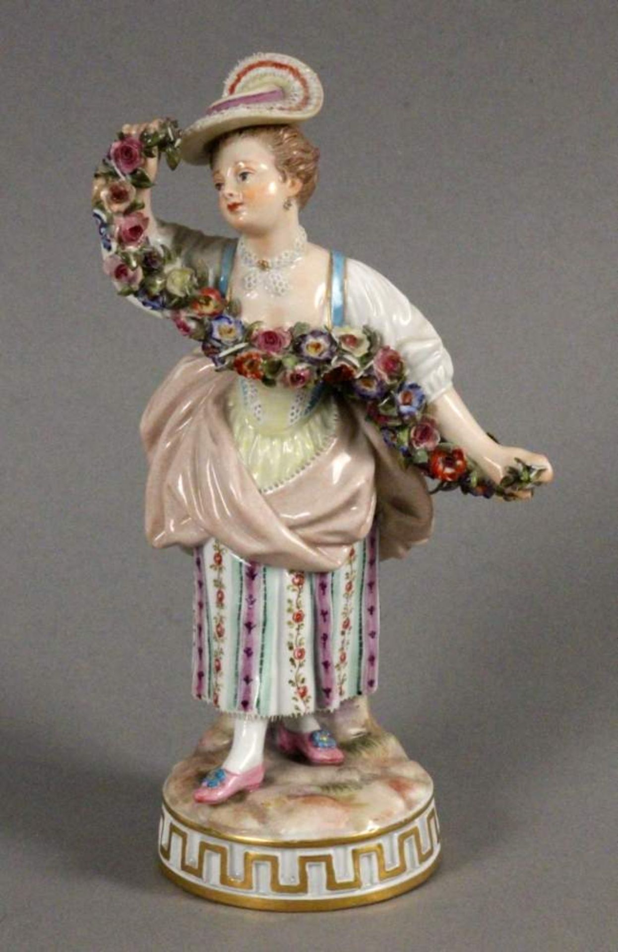 GÄRTNERFIGURMeissen um 1900 Bunt staffierte Mädchenfigur mit Blumengirlanden. Entwurf Victor Acier