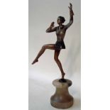 An Art Deco bronze patinated spelter figural model of a female dancer in a jacket and short skirt,