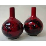 A pair of Royal Doulton Flambe ware Vases of bulbous bottle form, decorated in a woodcut design