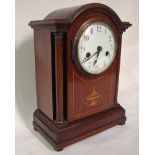 An Edwardian mahogany and inlaid cased Mantel Clock of break arch form with turned corner pilasters,