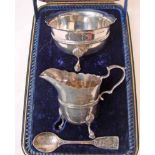 An Edwardian silver three-piece sugar and cream set consisting of a sugar bowl of circular form with