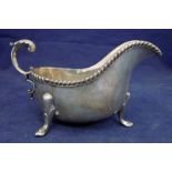 A George IV silver sauce boat of typical form, gadrooned rim, C scroll handle, set on three paw