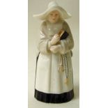 A Royal Worcester porcelain candle snuffer of figural form as a Nun with bible and rosary, puce