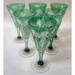 A set of seven Bohemian cut glass and green tinted champagne flutes of typical trumpet form with