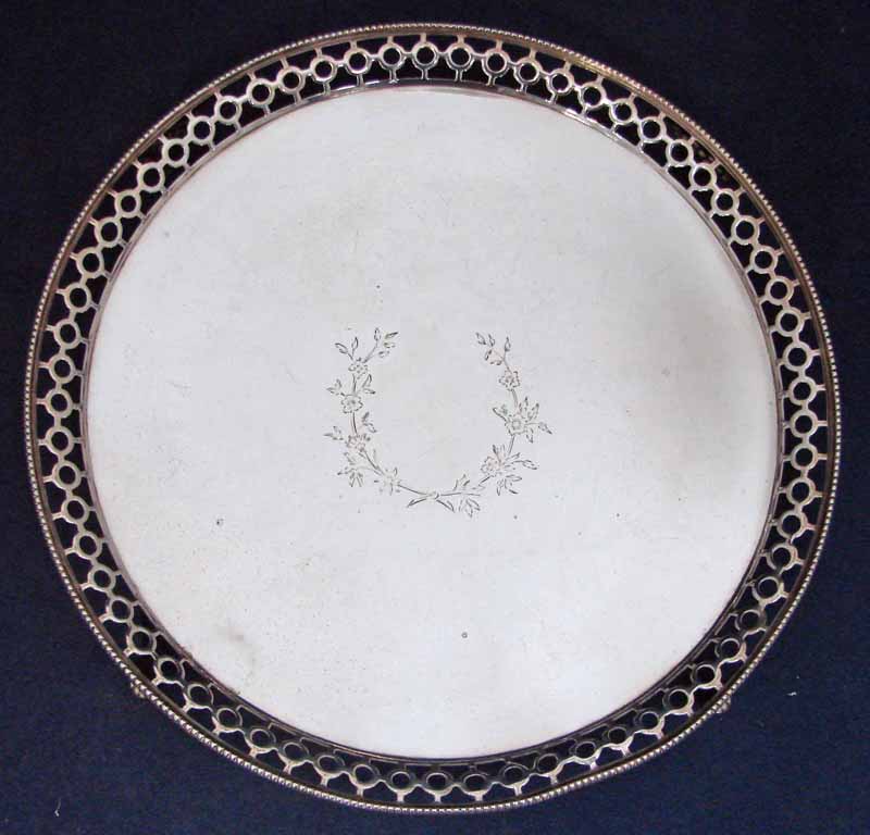 An Edwardian silver salver of circular form with pierced and beaded upturned rim, centrally engraved