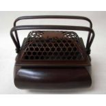 An oriental bronze box of compressed rectangular form with pierced domed removable cover and twin