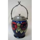 A William Moorcroft pottery biscuit barrel of typical form, tubeline decorated with pansies on a