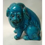 A Chinese turquoise glazed pottery model of a seated lion with swept back horns, 28cm high