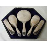 An Edwardian silver backed six piece dressing table set comprising a hand mirror, tortoiseshell