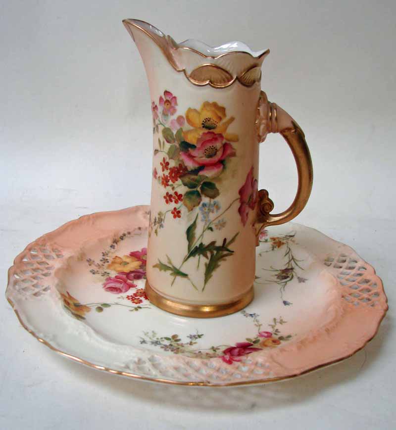 A Royal Worcester jug vase of tusk form, painted flower sprays on a blush ivory and gilt highlighted