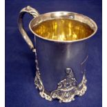 A Victorian silver tankard of circular form with everted rim, leaf capped S scroll handle, cast four