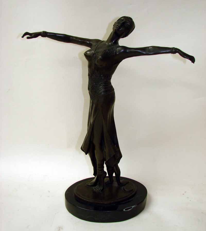 An Art Deco style bronze patinated figural model of a female dancer, standing on tip toes arms