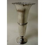 An early 20th century silver vase of tapering trumpet shape with cast scrolling lip, decoration on