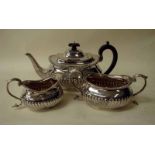 A late Victorian silver three piece tea service of typical oval form with half ribbed decoration,