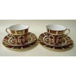 A pair of Royal Crown Derby bone china trios in the Old Imari design, number 1128 consisting of cup,