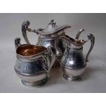 An Edwardian silver three piece tea service of compressed circular form with ribbed detail to rim,