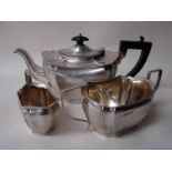 An early 20th century silver three piece tea service of lobed oval form consisting of a teapot