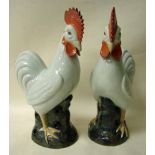 A pair of Chinese style large model cockerels, 20th century with scrafito plumage, crimson comb