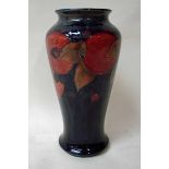 A William Moorcroft pottery vase of tall baluster form, tubeline decorated in the Pomegranate