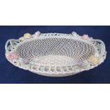 A Belleek porcelain basket, of oval form, flower and shamrock encrusted hooped cane effect rim, open