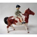 A Beswick pottery model Girl on Skewbald Pony, number 1499, gloss finish, oval stamp, 14.5cm high