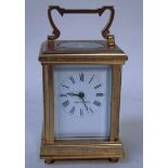 A small French brass carriage clock, 20th century, white face with Roman numerals, foliate chased