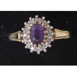 A modern 9ct gold amethyst and diamond ring of oval cluster form with a central amethyst