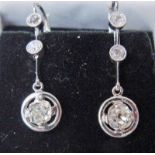 A modern pair of platinum and diamond drop earrings, each set with two 0.16ct (approx) brilliant cut