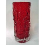 A Whitefriars glass vase of cylindrical form, ruby red, bark pattern, designed by Geoffrey Baxter,