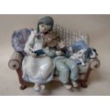 A Lladro porcelain figural group, Big Sister, number 5735, girls and puppy on a settee, 18cm high