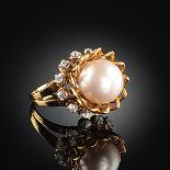 AN 18K YELLOW GOLD, PEARL, AND DIAMOND LADY'S RING, the mounting centering one 10.35 millimeter half