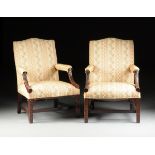 A PAIR OF GEORGE III STYLE UPHOLSTERED AND CARVED MAHOGANY LIBRARY ARMCHAIRS, each with an arched