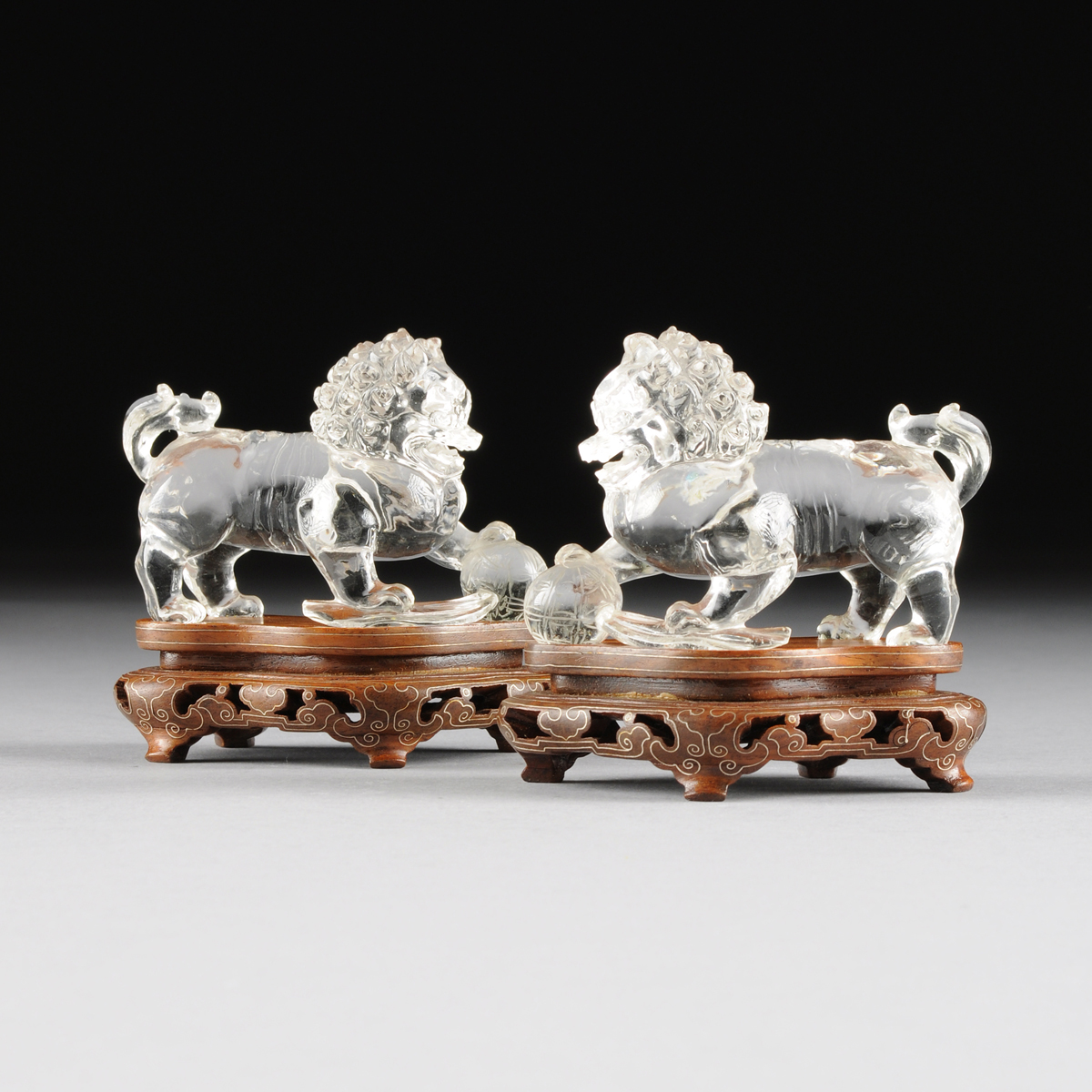 A PAIR OF CHINESE CARVED ROCK CRYSTAL BUDDHISTIC LIONS, 20TH CENTURY, in a seated position and